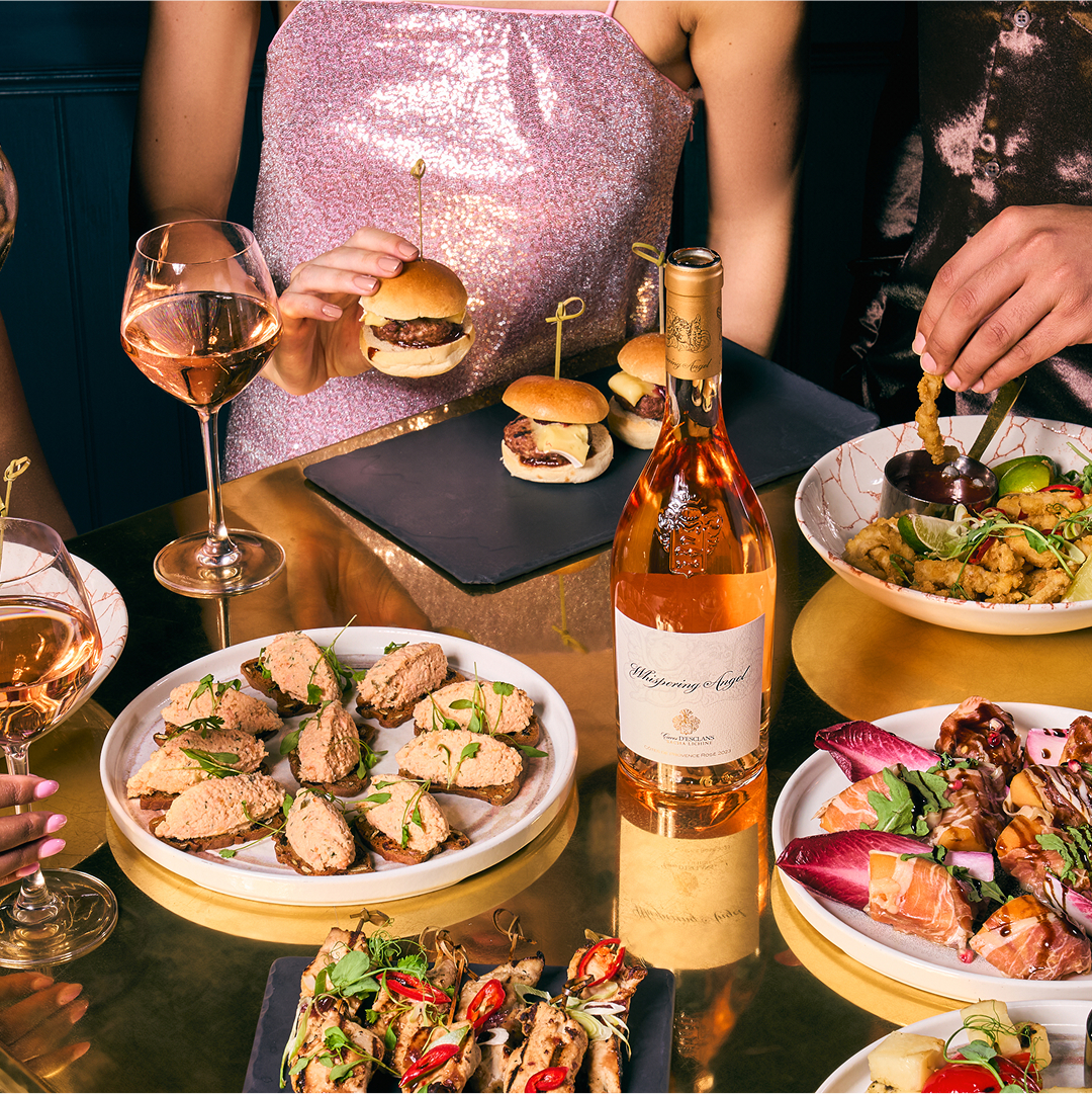 An example of food laid out around a bottle of Champange on a table